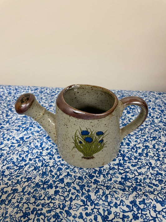 speckled watering can blue flower