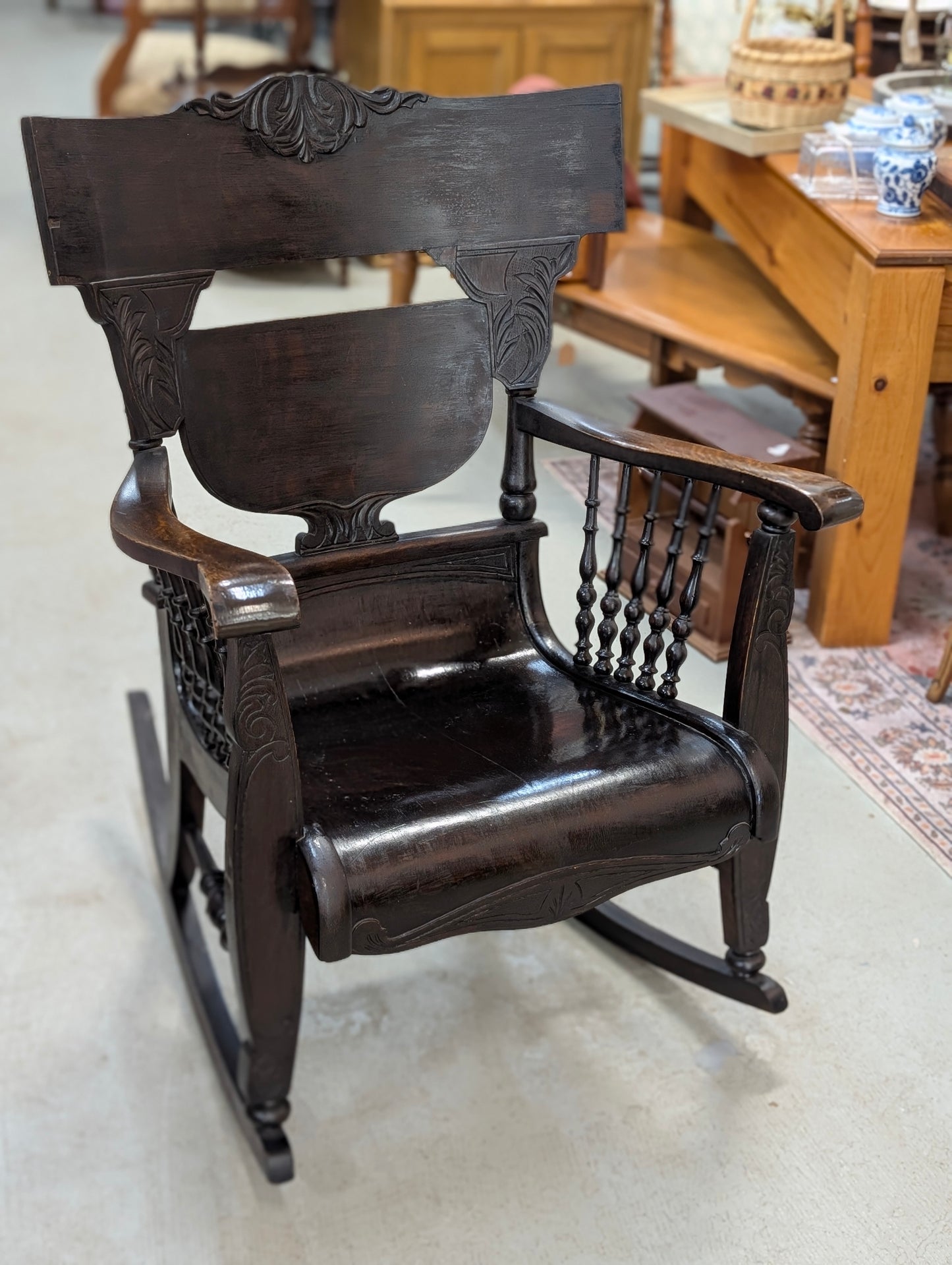 antique dark oak rocking chair with carved back and turned spindles