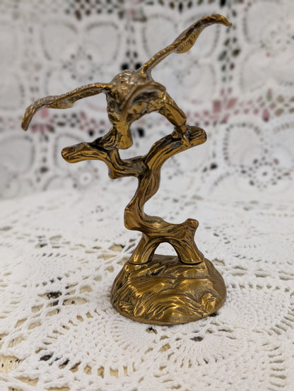 Brass bird on branch